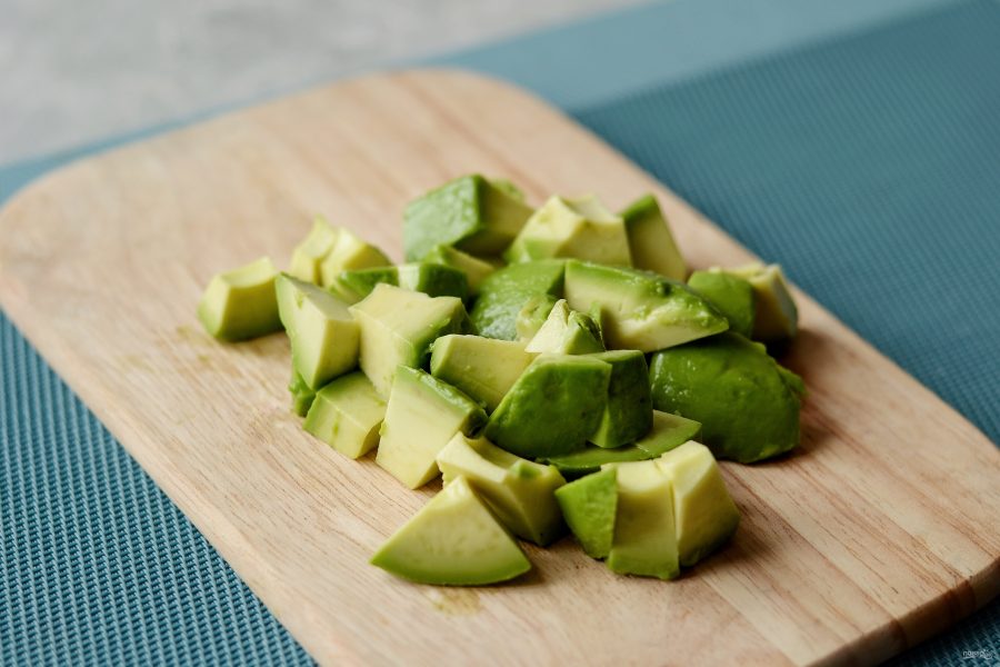 Очистите авокадо от кожуры, нарежьте кубиками.